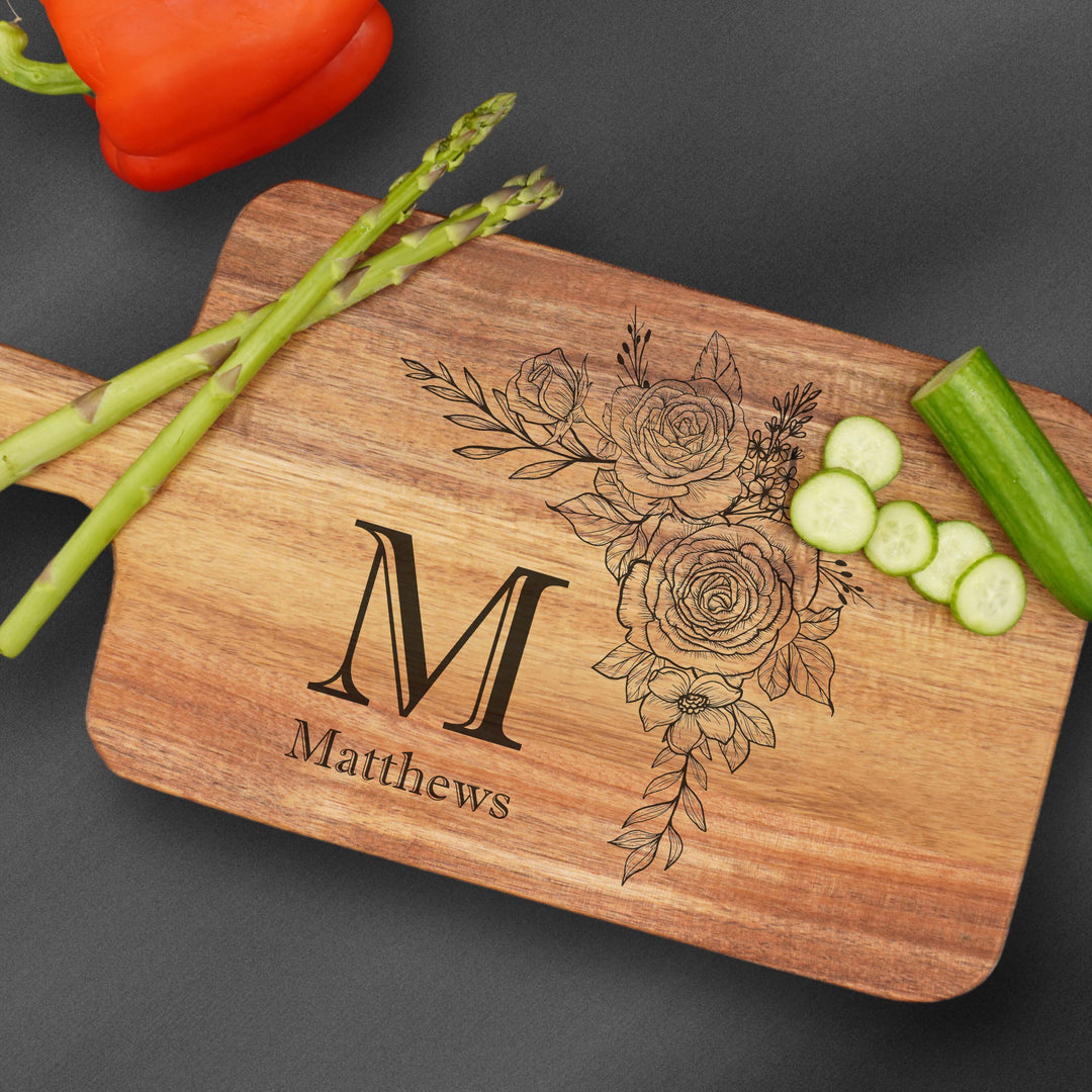 Cutting board with handle and an initial M with a last name Matthews and flower.