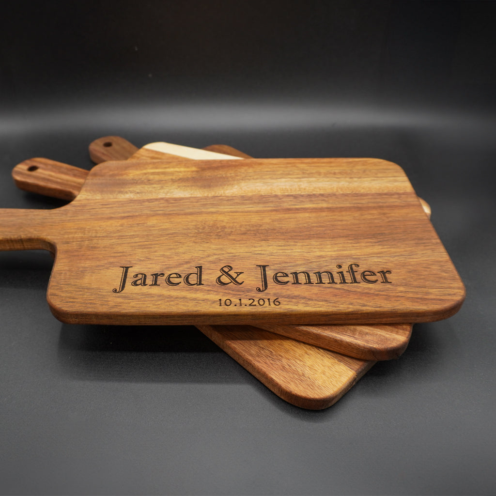 Handcrafted wooden cutting board with handle, featuring personalized laser engraving for a unique kitchen gift