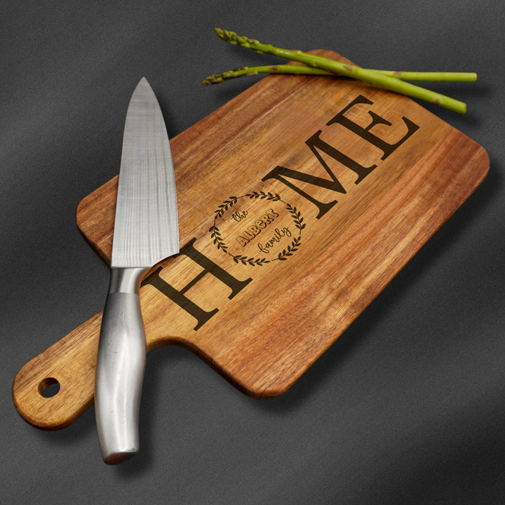 Personalized wooden cutting board engraved with a family name.