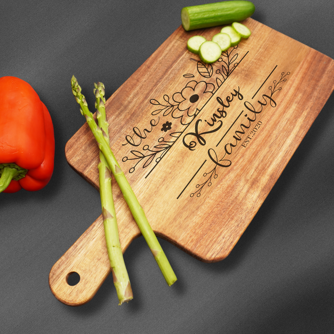 Cutting board with a handle that is laser engraved with a family name and design