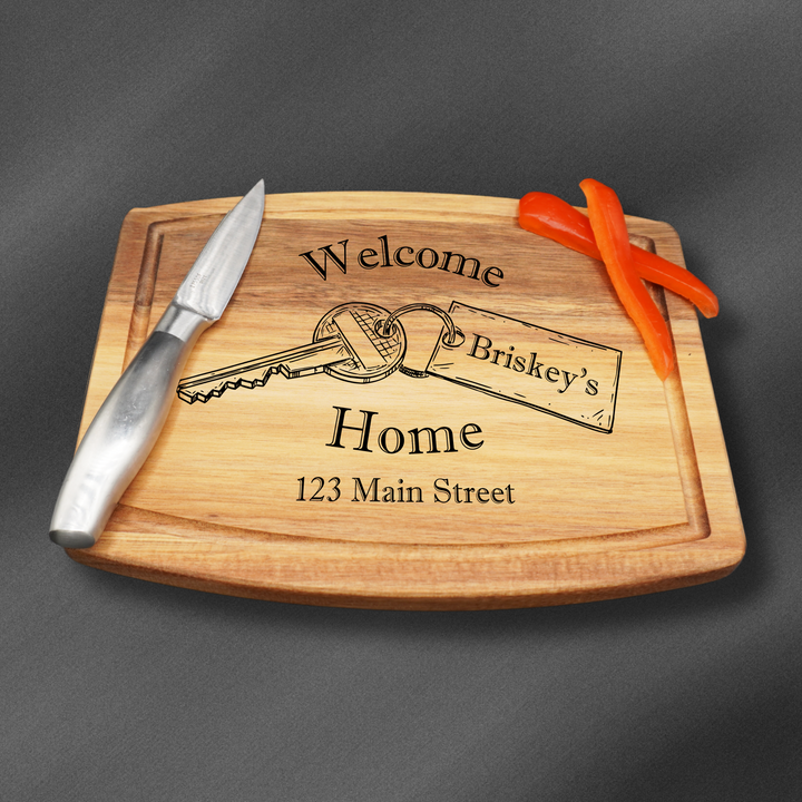Personalized Rectangle Cutting Board with a welcome home engraving and a key.